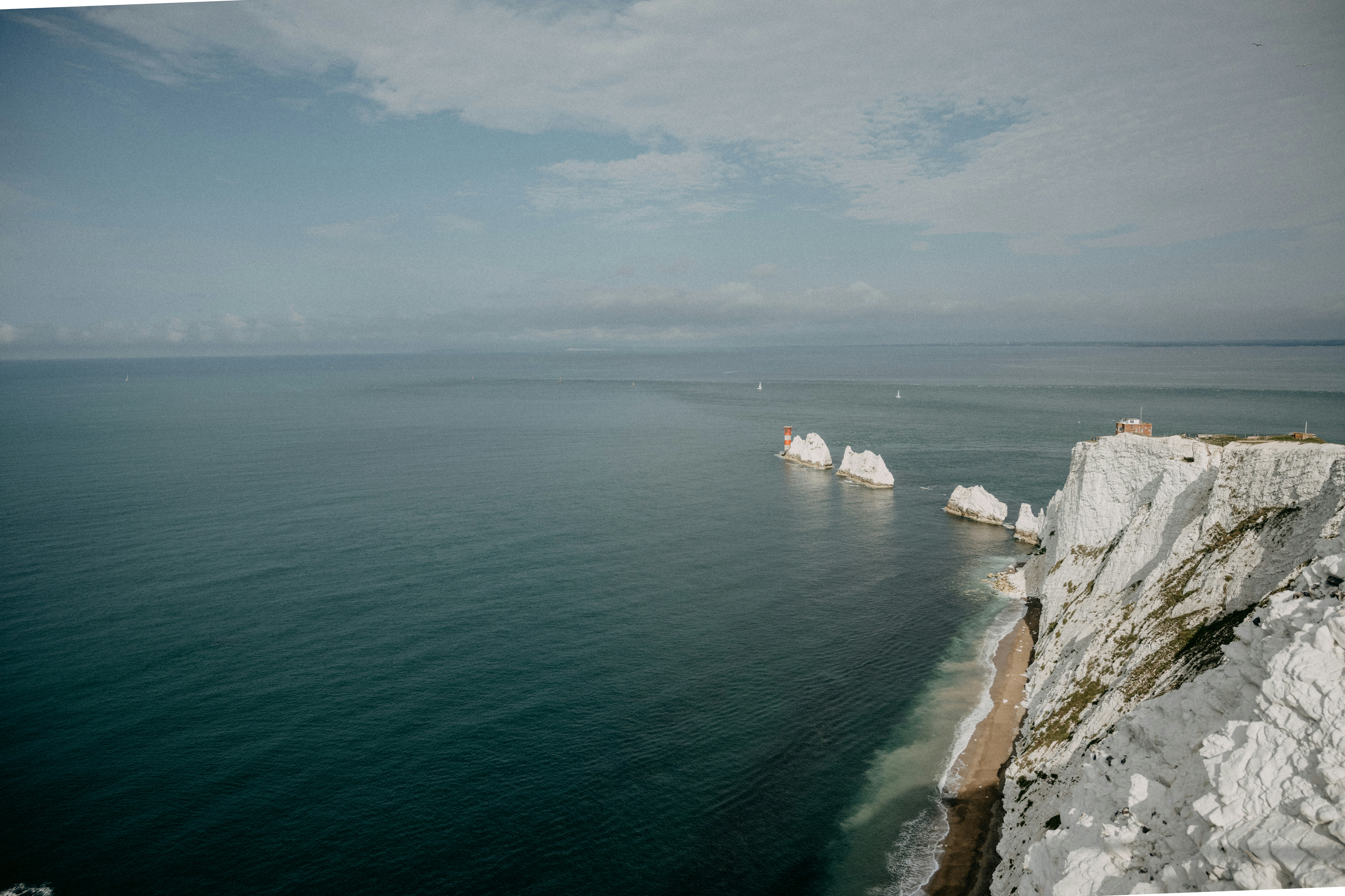 white and brown rock formation beside body of water during daytime